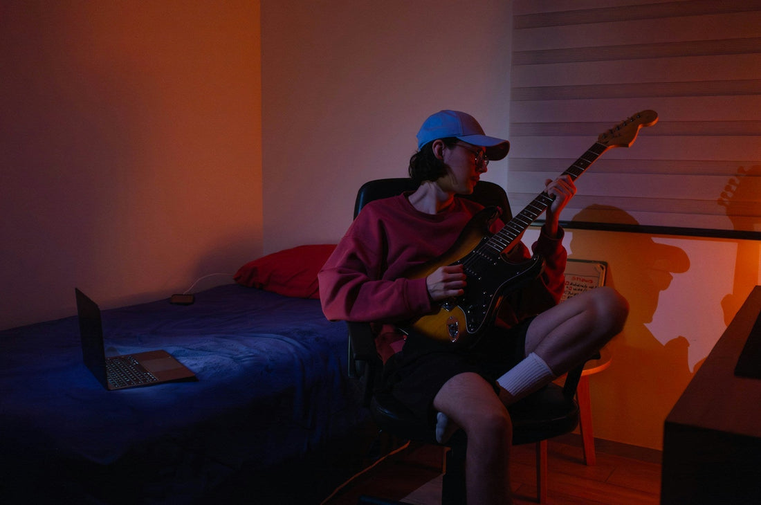 A musician playing his guitar in a dimly lit room